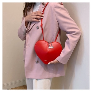 Détail du sac à bandoulière rouge en forme de cœur avec fermeture éclair métallique