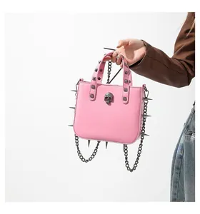 Pink punk handbag featuring silver skull stud and sharp metallic spikes on the bottom edge