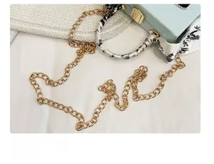 Detail der hellblauen Box-Tasche mit Goldkette und gebundenem Seidenschaltuch