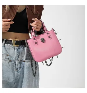 Detail of pink gothic punk handbag featuring silver metal skull and rivet decorations