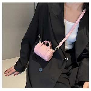 Detail of pink mini cylindrical bag with pebble grain leather texture and brand logo