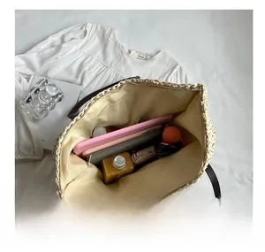 Detailed interior of woven straw tote showing space for tablet, notebook, and water bottle