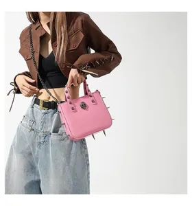 Pink punk bag detail featuring metallic skull decor and sharp silver studs with chain strap