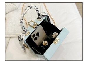 Detail der hellblauen Box-Tasche mit Schalgriff zeigt Platz für Handy und Make-up im Inneren