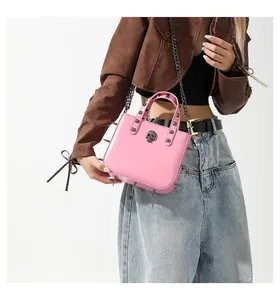 Close-up of pink gothic punk handbag featuring silver skull stud and decorative spikes