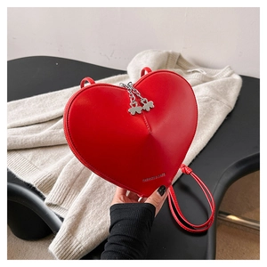 Détail du sac bandoulière coeur rouge en cuir avec fermeture éclair trèfle argenté