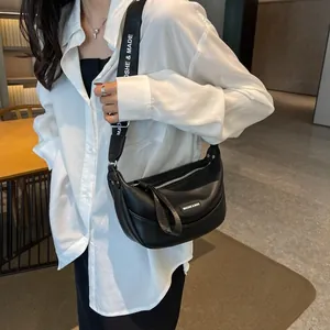 Detail of black semi-circle matte leather crossbody bag with wide lettered shoulder strap
