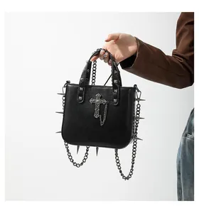 Close-up of gothic punk handbag featuring metal studs, sharp spikes and a cross pendant