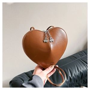Détail du sac coeur en cuir marron avec zips trèfle et gravure fashion élégante
