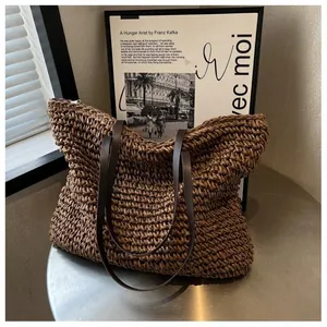 Close-up of thick brown woven texture and leather strap on this large straw tote bag