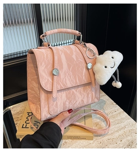Detailed texture of pink wrinkled leather bag featuring a cute white cloud charm
