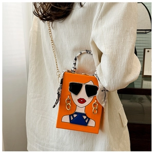 Detail der orangefarbenen Clutch mit Frauen-Illustration und goldener Kettenschultergurt