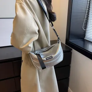 Detail of silver crescent bag with textured leather and adjustable branded strap
