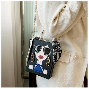 Detail einer schicken schwarzen Abendtasche mit Kunst-Collage und dekorativem Seidenschal-Griff