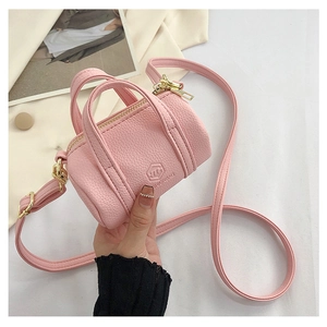 Detail of pink mini boston bag with lychee texture and embossed fashion lettering