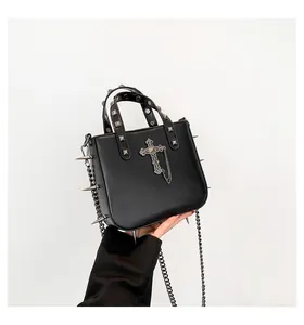 Detail of gothic black purse with silver metal spikes and metallic cross pendant