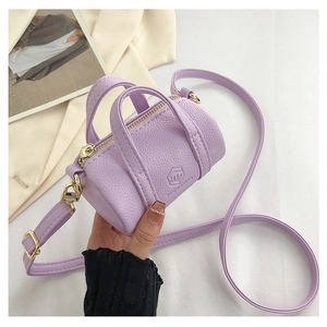 Close-up of lavender mini cylinder handbag with litchi grain texture and gold zippers