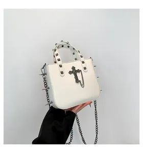 Gothic white leather handbag featuring black cross, silver studs, and metal chain details