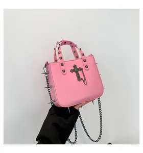 Pink gothic crossbody bag detail showing silver rivets and metallic cross pendant detail