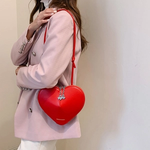 Sac à bandoulière minimaliste en cuir PU rouge en forme de cœur porté par un mannequin