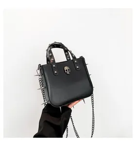 Detail of gothic handbag featuring silver skull, square studs and punk spikes with chain