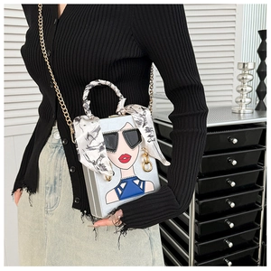 Details der silbernen Abendtasche mit Pop-Art-Motiv und seidig umwickeltem Griff