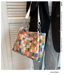 Detail of colorful checkered tote bag with metal chain strap and Niche Design label