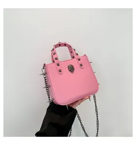 Pink punk crossbody bag with metallic black skull emblem and decorative long spikes