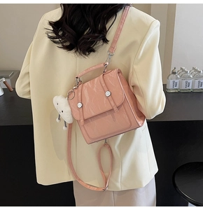 Close-up of pink glossy patent leather bag with wrinkled texture and cloud charm