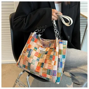 Detail of colorful woven plaid tote with silver chain and Niche Design label