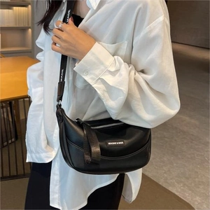 Fashionable black crescent crossbody bag with branded wide strap for women in a modern setting