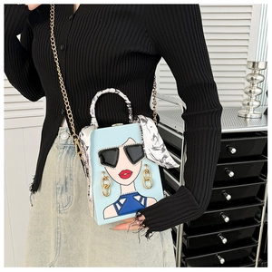 Detail der hellblauen Box-Tasche mit Pop-Art-Porträt und mit Seidenschal umwickeltem Griff