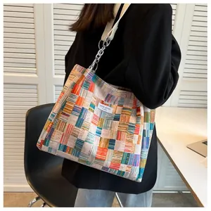 Detail view of colorful patchwork tote bag with chain strap and Niche Design label