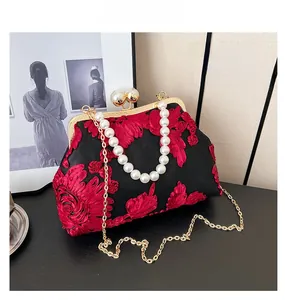 Détail du sac vintage noir avec broderie florale 3D rouge et poignée en perle