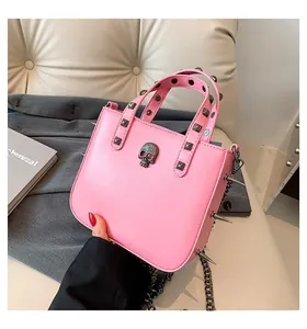 Pink punk handbag with silver skull charm, square studs, and metallic chain detail