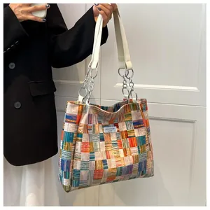 Detail of plaid woven tote bag with metallic chain strap and Niche Design label