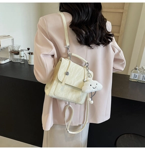 Detail of marble texture backpack with ring buckle and plush cloud charm on a model