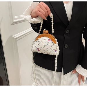 Detail of vintage style crossbody bag with butterfly embroidery and pearl chain strap