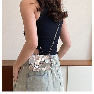 Close-up of silver sequin mini bag with large round mirrors and silver chain strap