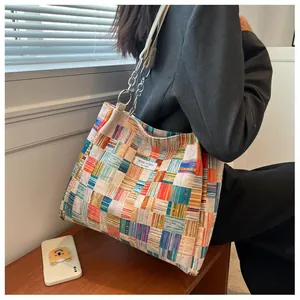 Detail of multi-color plaid tote bag with silver chain strap and Niche Design label