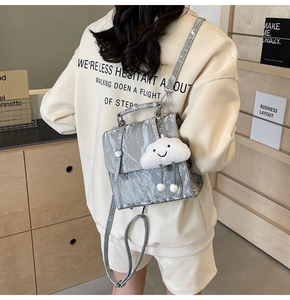 Detail showing metallic crinkle texture backpack with cute cloud plush charm