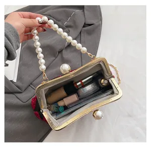 Détail de l'intérieur du sac coquille avec poignée en perles et grand espace de rangement