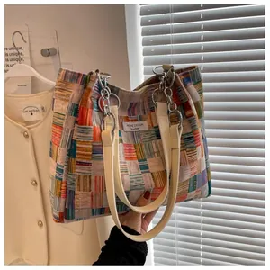 Detail of multi-color checkered tote bag featuring Niche Design label and silver hardware