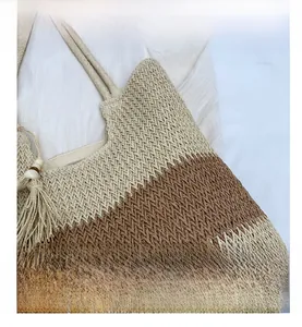 Detail of woven straw tote bag featuring two-tone V-shaped texture and fringe tassel
