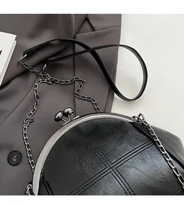 Detail of lychee textured leather chain bag with classic metal clasp and stitch work