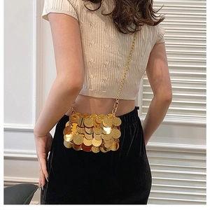 Detail view of mini gold sequin crossbody bag with chain strap worn on model