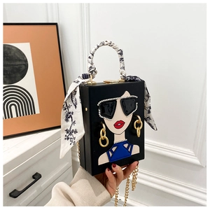 Detail der kreativen schwarzen Box-Handtasche mit Strass-Sonnenbrillen-Muster und Seidentuch-Griff