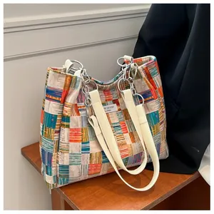 Detail of colorful patchwork plaid tote bag with silver chain and leather shoulder strap
