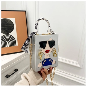 Details der silbernen Abendtasche mit Strass-Sonnenbrillen-Motiv und seidig umwickeltem Griff