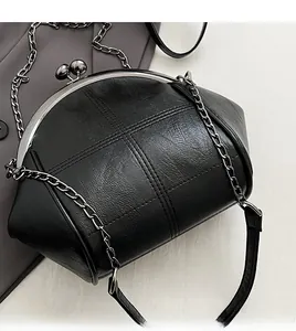 Detail of cross-stitched black shell bag with gunmetal hardware and thick chain strap